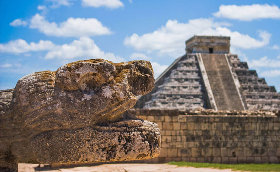 Kukulkan head sculpture in front of Chichen Itza pyramid